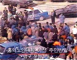 More than 200 enraged local citizens rushed to the site to protest against the illegal temple (from Korean MBC TV), a police car can been seen to the left